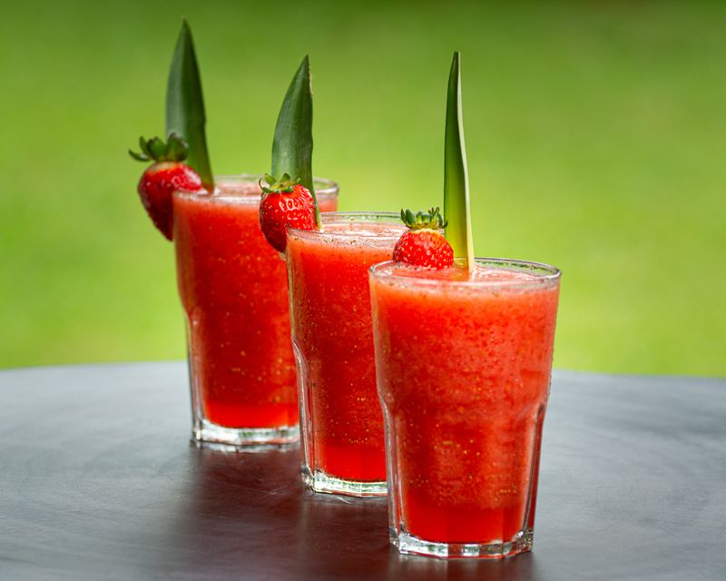 Drie glazen aardbeiengazpacho met een aardbei als garnering